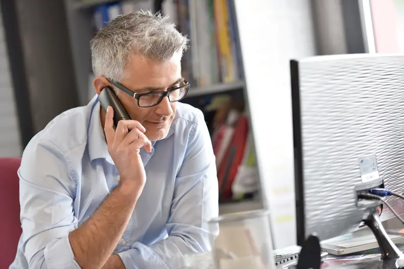 Man speaking on the telephone at a desk