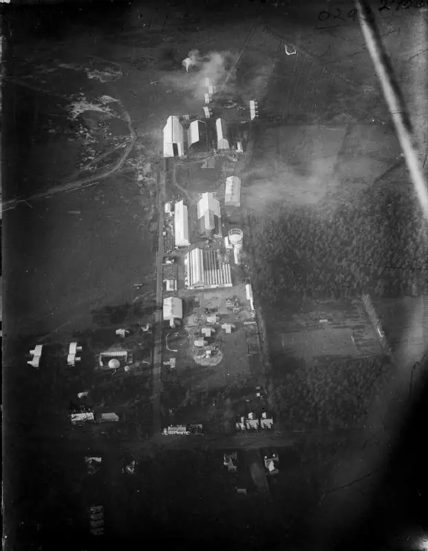 Aerial photograph from 1912 of the Royal Aircraft Factory at Farnborough, showing rows of large sheds beside tracks and woodland