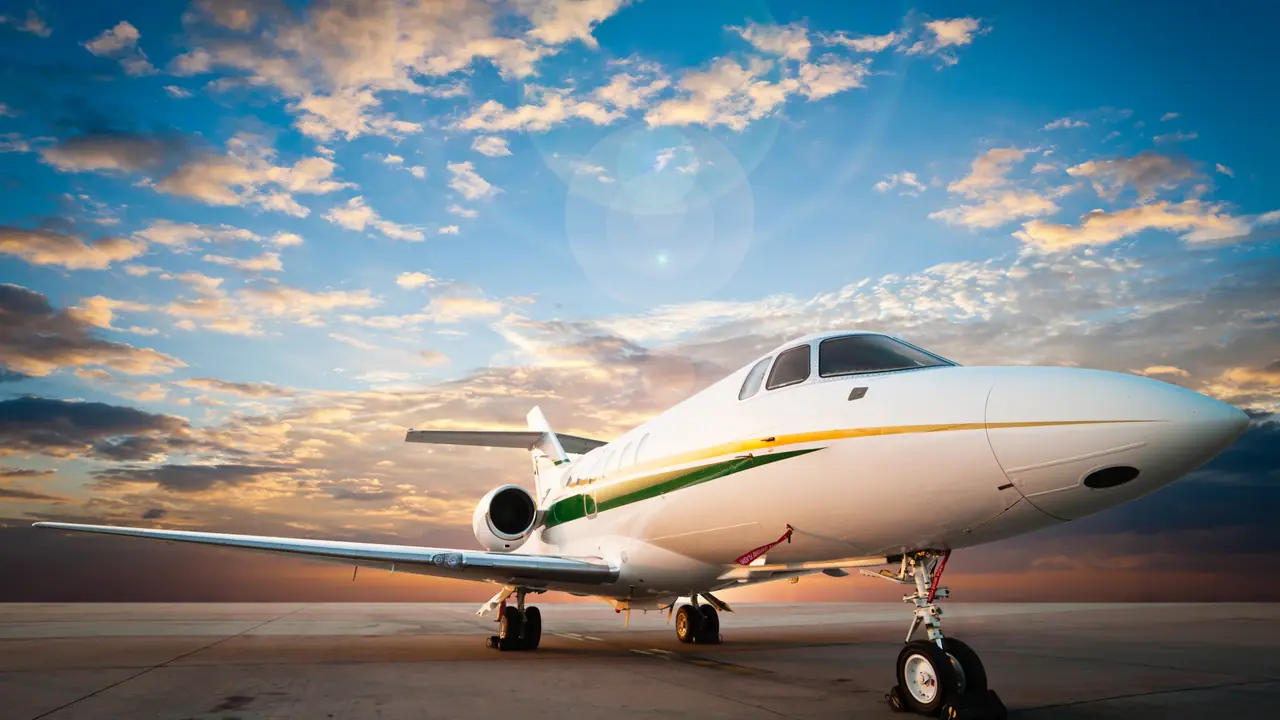 Private jet on the apron beneath a golden evening sky