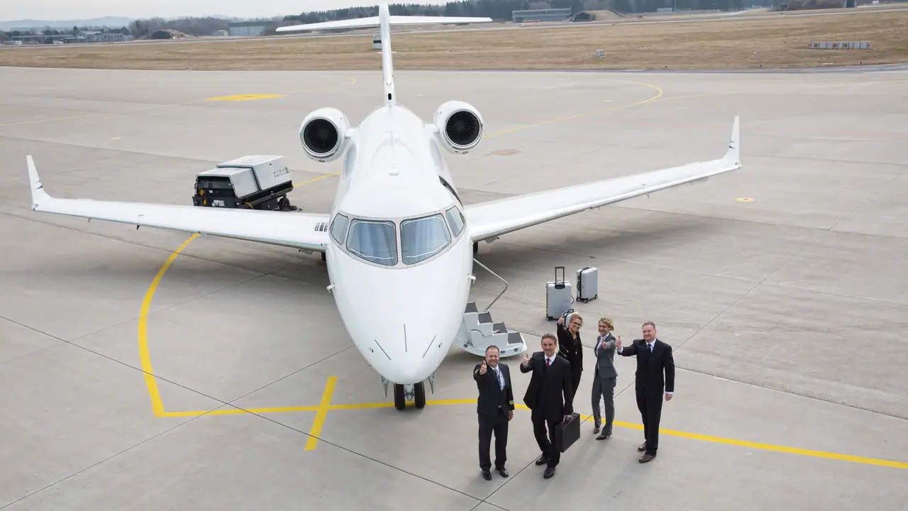Passengers walking from a private jet with their crew